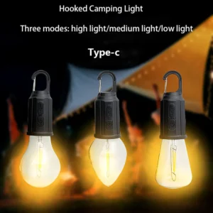 Vintage hanging outdoor lantern glowing with warm light inside a camping tent.