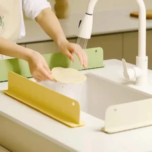 Grey silicone sink splash guard attached securely to the front edge of a kitchen sink counter.