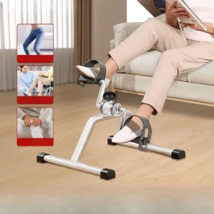 Black portable mini under-desk exercise bike being pedaled by a person sitting in an office chair.