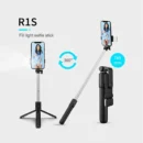 Foldable selfie stick extended into a mini tripod holding an iPhone on a flat surface.