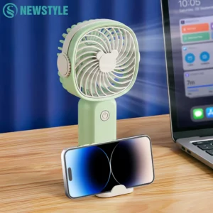 Handheld mini fan sitting securely on its removable desktop stand on a student study desk.