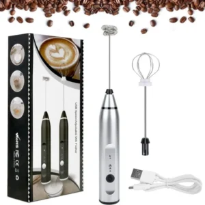 Handheld electric beater with a stainless steel whisk attachment frothing milk in a glass coffee mug.