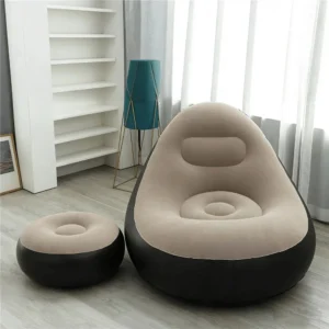 Flocked inflatable sofa with a matching leg rest footstool set up on a beautiful sandy beach.