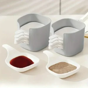 Minimalist white ceramic sauce dish set filled with tomato ketchup and soy sauce on a dining table.