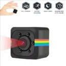 Small black mini camera HD lens hidden discreetly between books on an office shelf for security.