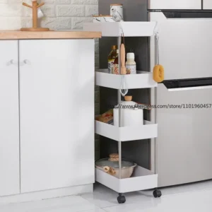 White 4-layer slim rolling utility storage rack loaded with bottles sliding neatly into a tight gap between a refrigerator and kitchen counter.