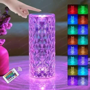 Diamond-cut acrylic crystal lamp glowing with a warm rose pattern light reflection on a wooden bedside table.