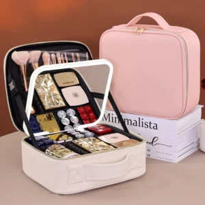 Open pink leather travel makeup organizer bag showing cosmetics neatly arranged in dividers under a glowing LED mirror.