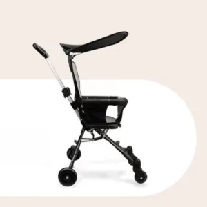 Compact black baby stroller folded neatly next to a carry-on suitcase in an airport terminal lobby.