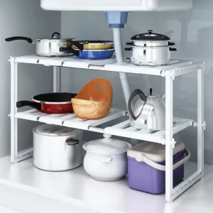 White 2-tier expandable under sink organizer with removable panels fitted around plumbing pipes under a bathroom sink.